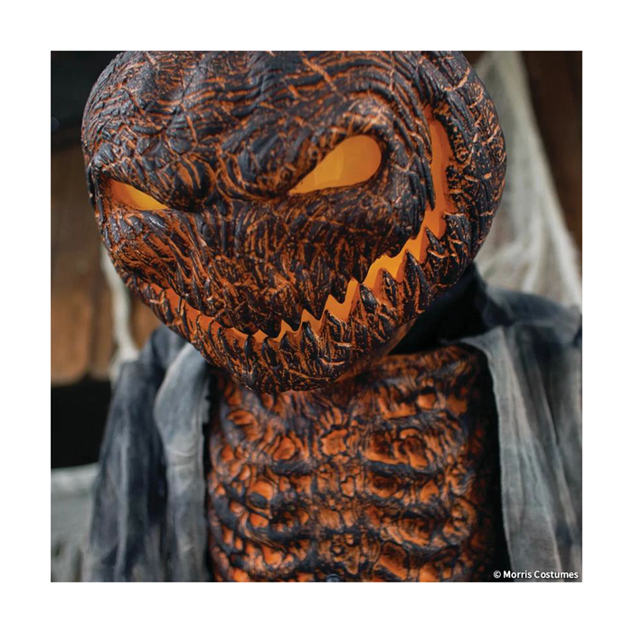 Detalle de la cabeza de calabaza quemada con ojos y boca iluminados
