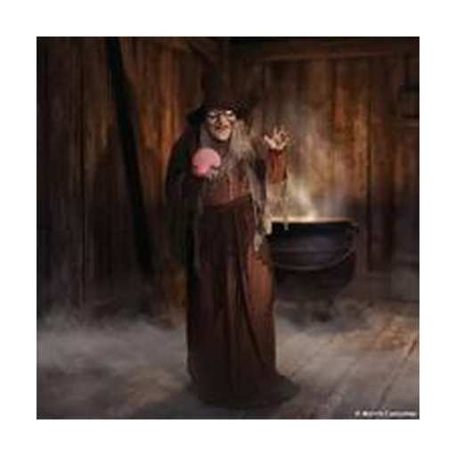 Animatronic bruja adivina junto a un caldero en una escena de Halloween