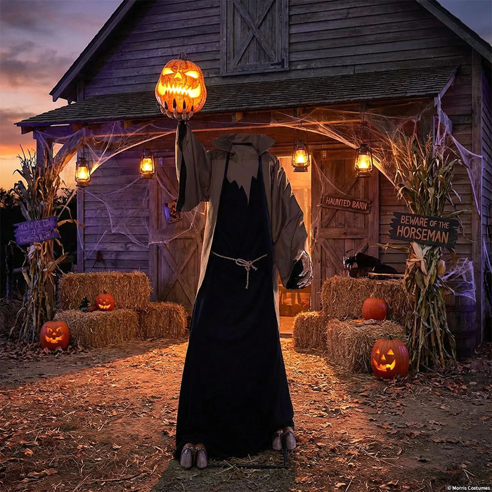 Encapuchado con calabaza iluminada frente a una cabaña en una escena de Halloween