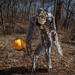 Esqueleto con calabaza iluminada en un bosque en una escena de Halloween