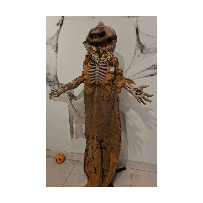 Animatronic hombre calabaza con cabeza de arpillera, torso de esqueleto y túnica café manchada, armado, foto real en tienda