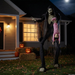 Animatronic esqueleto gigante con niña frente a una casa decorada para Halloween