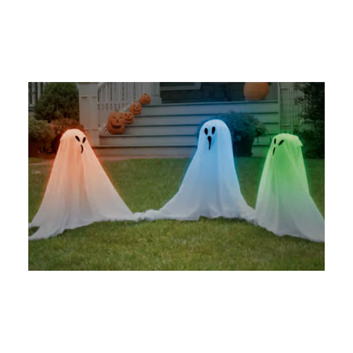 Tres fantasmas luminosos de tela blanca iluminados en el jardín de una casa