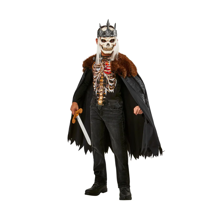 Niño con disfraz de rey muerto: máscara de calavera con corona plateada, capa negra con borde de piel café y polera con esqueleto