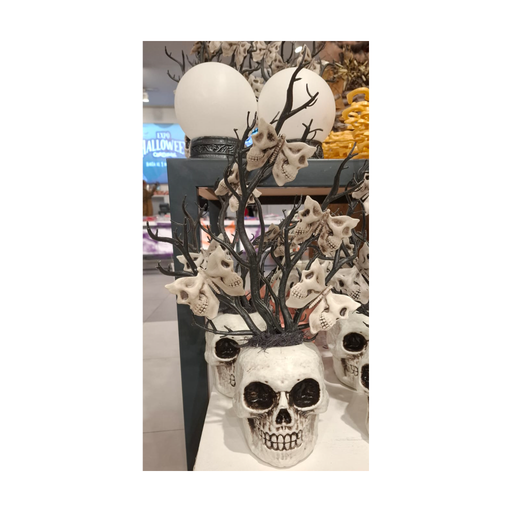 Florero calavera blanca con ramas negras y polillas de calavera, foto real en tienda