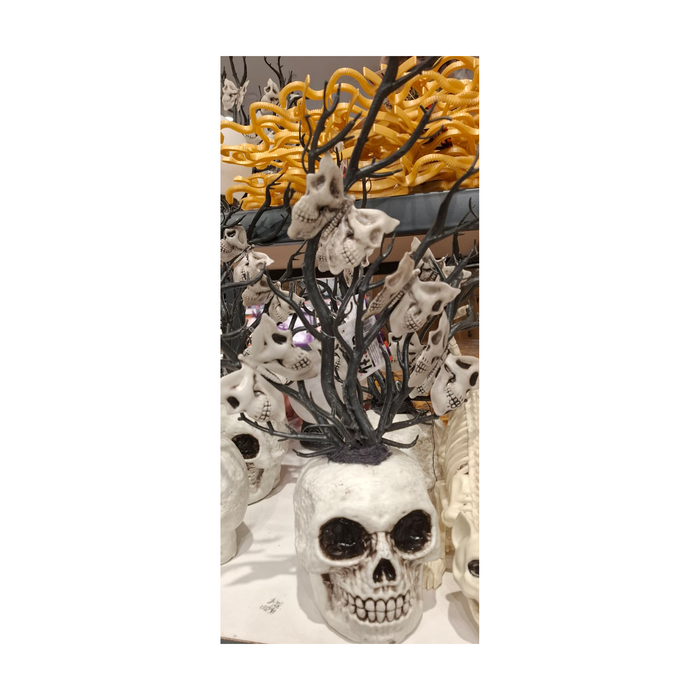 Detalle del florero calavera con ramas negras y polillas de calavera, foto real en tienda