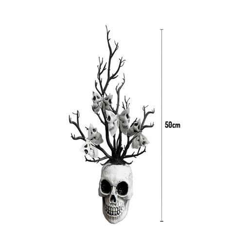 Florero de calavera blanca con ramas negras decoradas con pequeñas calaveras