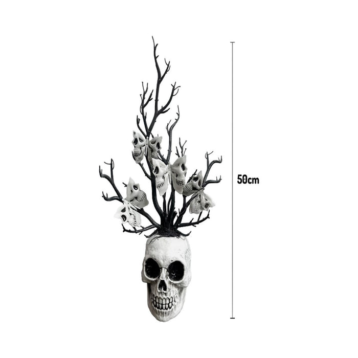 Florero de calavera blanca con ramas negras decoradas con pequeñas calaveras
