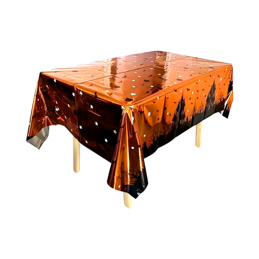 Mantel de Halloween naranjo metalizado con siluetas de casa embrujada, murciélagos y estrellas sobre una mesa