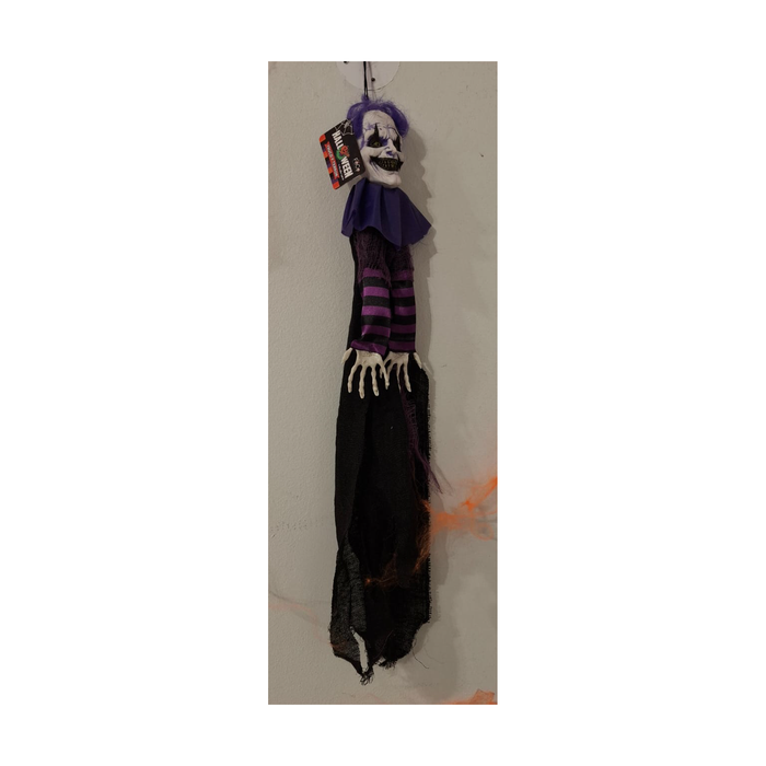 Payaso colgante de 60 cm con pelo y cuello morado, mangas a rayas y capa negra, colgado en un muro, foto real en tienda