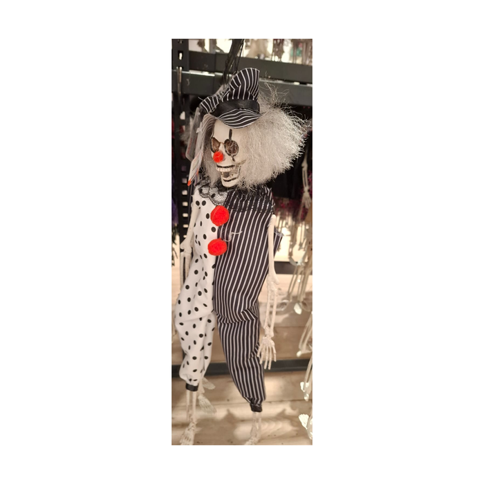 Payaso esqueleto colgante con sombrero a rayas, pelo blanco, nariz roja y traje blanco y negro con lunares y pompones rojos, foto real en tienda