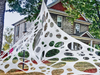 Telaraña gigante elástica blanca estirada frente a una casa, decoración de Halloween