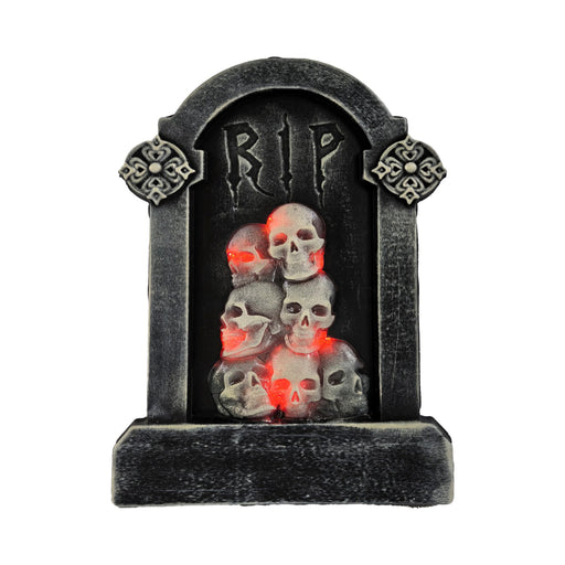 Tumba gris con inscripción RIP y calaveras iluminadas con luz roja