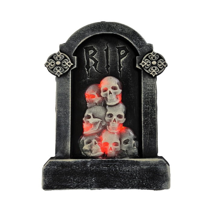 Tumba gris con inscripción RIP y calaveras iluminadas con luz roja